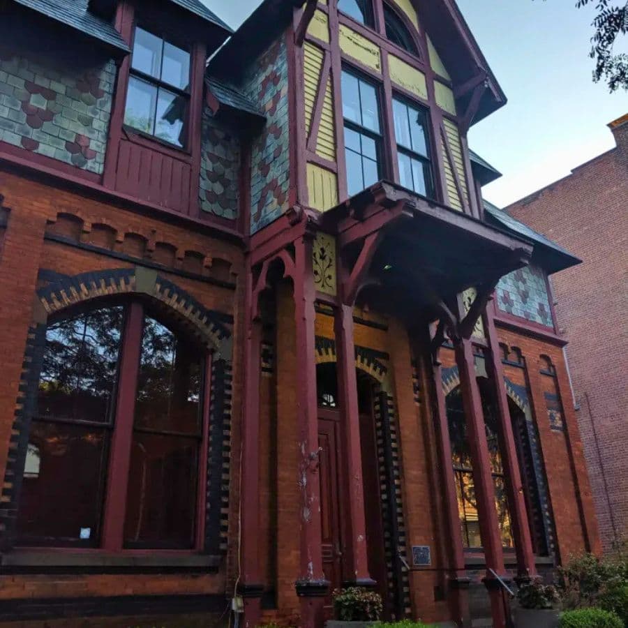Victorian-style brick house with colorful slate accents and ornate architectural details.