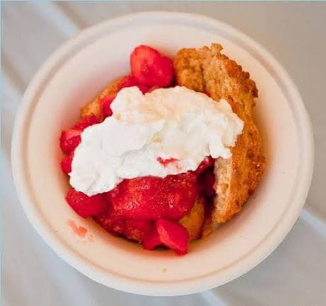 A bowl of strawberry shortcake topped with whipped cream. A bowl of strawberry shortcake topped with whipped cream.